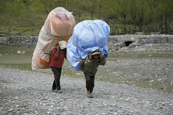 Porteadores que llevan cargas pesadas en la espalda, annapurna, nepal — Foto de Stock