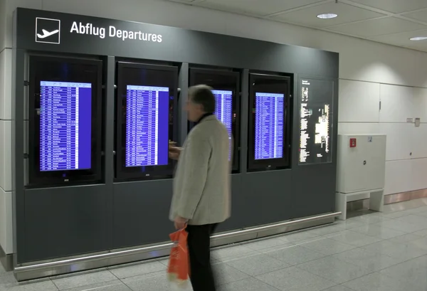 Hombre mirando el panel de información de vuelo en el aeropuerto — Foto de Stock
