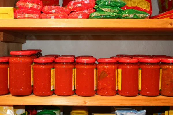 Jars of tomato sauce on the shelf in an organic shop — Stock Photo, Image