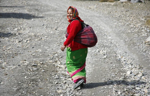 Traditionally dressed gurung lady walking along path in the annapurna, nepa — Stock Photo, Image