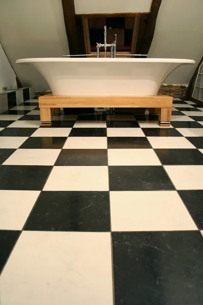 Vista vertical de la bañera en el suelo de baldosas en blanco y negro — Foto de Stock