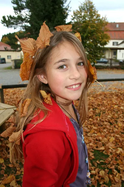 Junges Mädchen liegt in Herbstblättern — Stockfoto