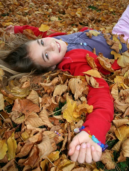 Young girl lying in autumn leaves — Stock Photo, Image