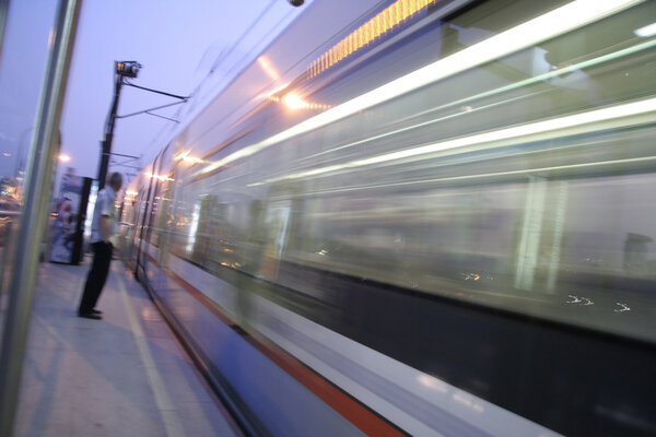 Man waiting for blurred tram, istanbul, turkey