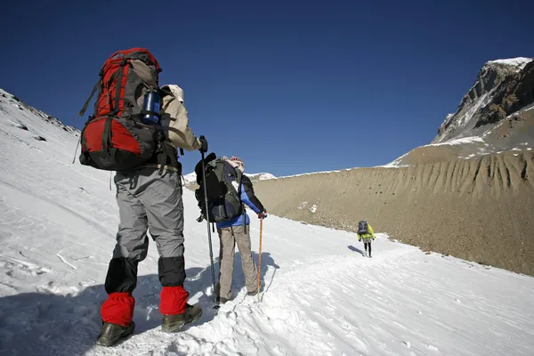Caminantes siguiendo el camino de la cumbre de la montaña — Foto de Stock