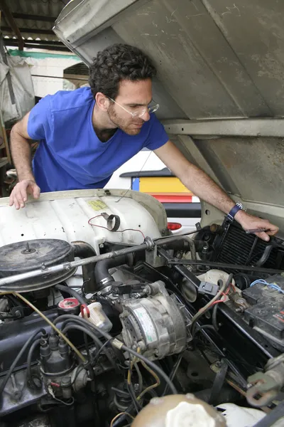 Jonge man doen mechanische werken op auto motor — Stockfoto