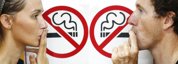 Couple smoking a no smoking sign