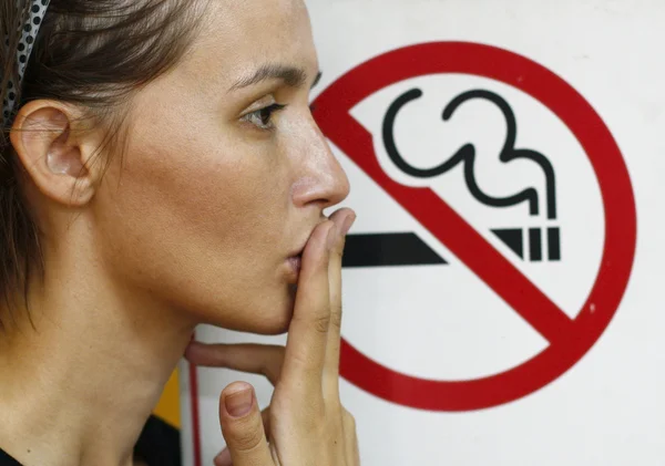 Lady smoking a non-smoking panel — Stock Photo, Image