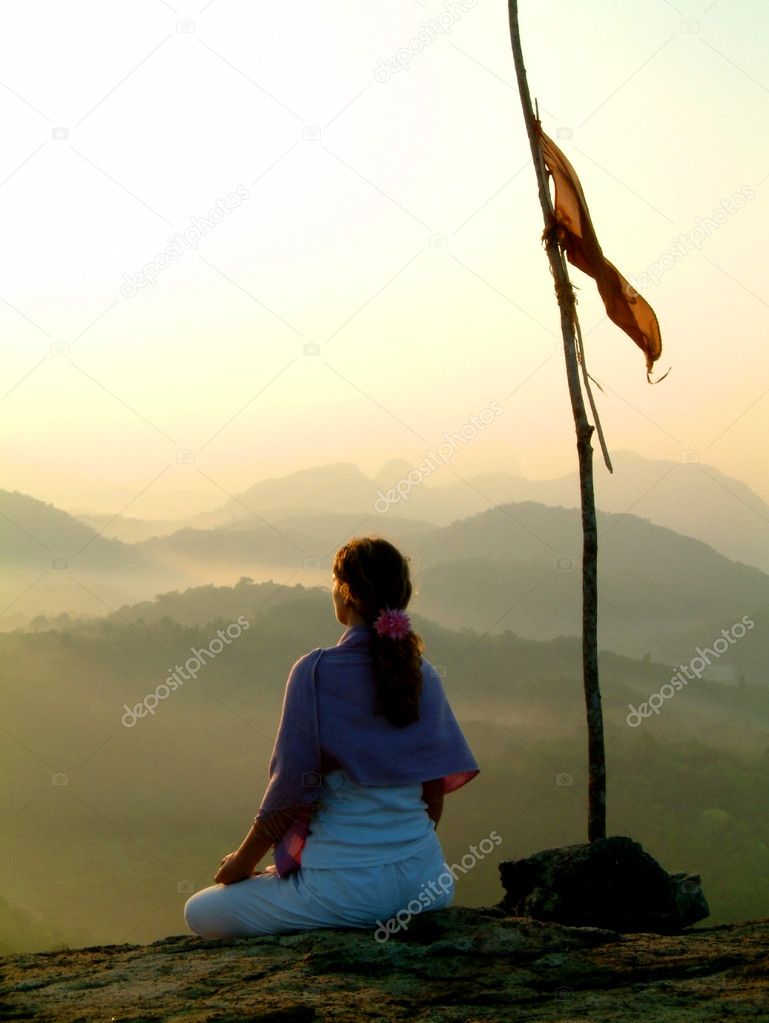 Lady meditating at sunrise
