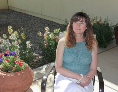 A Woman Sits on a Patio Among Garden Flowers clipart