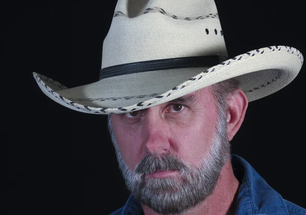 En man med grått skägg i en vit stråhatt cowboy — Stockfoto