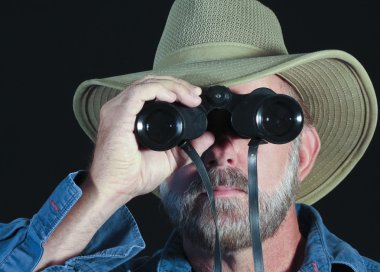 A Man in a Safari Hat Looks Through Binoculars clipart