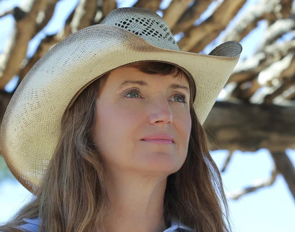 Una mujer en un sombrero de vaquero debajo de una ramada —  Fotos de Stock