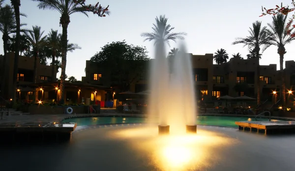 Una fuente de piscina en un hotel resort en Twilight —  Fotos de Stock