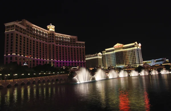 A night shot of the Bellagio fountain show and Caesars Palace — Stock Photo, Image