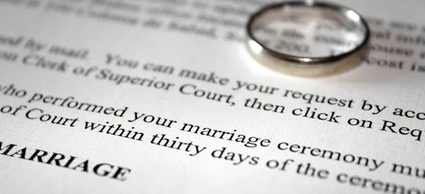 Um certificado de casamento e anel de casamento de ouro — Fotografia de Stock
