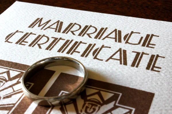 Un certificado de matrimonio y anillo de bodas de oro —  Fotos de Stock