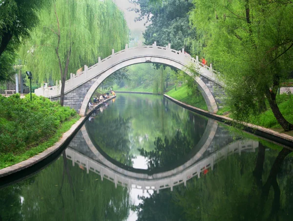 Μια γέφυρα πάρκο αντανακλάται σε μια πλωτή οδός — Φωτογραφία Αρχείου