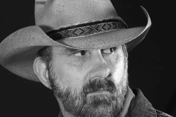 Un cowboy aruncă o privire peste umărul său în alb și negru — Fotografie, imagine de stoc