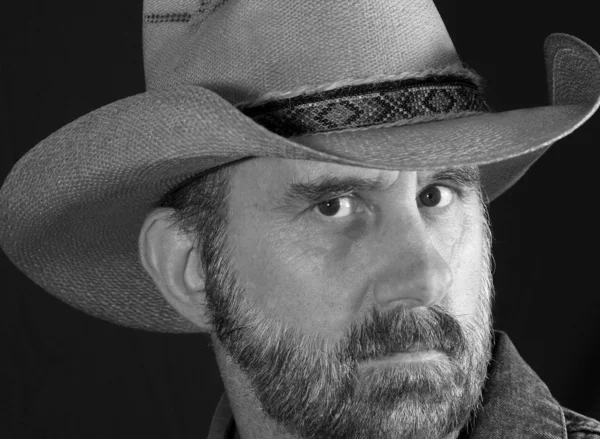 En cowboy med något förhöjd panna i svart och vitt — Stockfoto