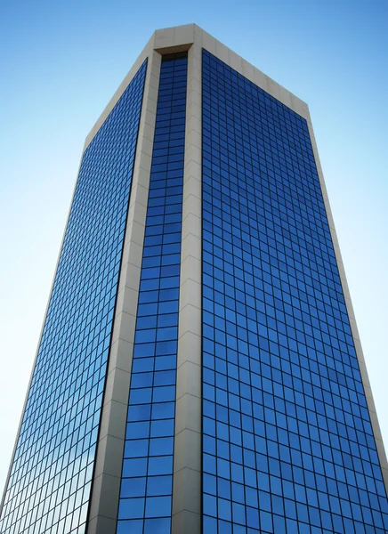 Ein hoher gläserner Turm spiegelt himmelblau — Stockfoto