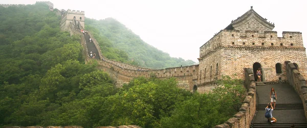 Мужчина фотографирует женщину на Великой китайской стене — стоковое фото