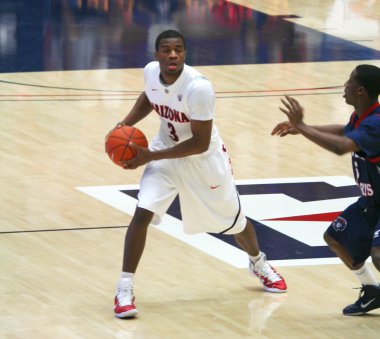 bir defans oyuncusu kevin parrom bir arizona basketbol oyununda kovalıyor.