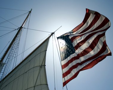 An Amrican Flag Flies on a Sailing Ship clipart