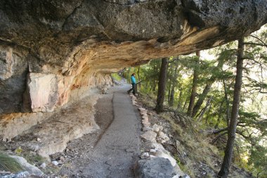 A Woman Reads a Placard in Walnut Canyon clipart