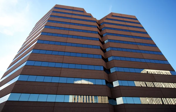Um par de edifícios de escritórios refletidos em outro — Fotografia de Stock