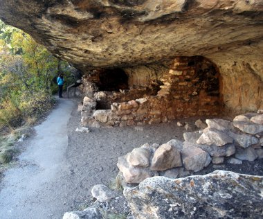 A Woman Reads a Cliff Dwelling Placard in Walnut Canyon clipart