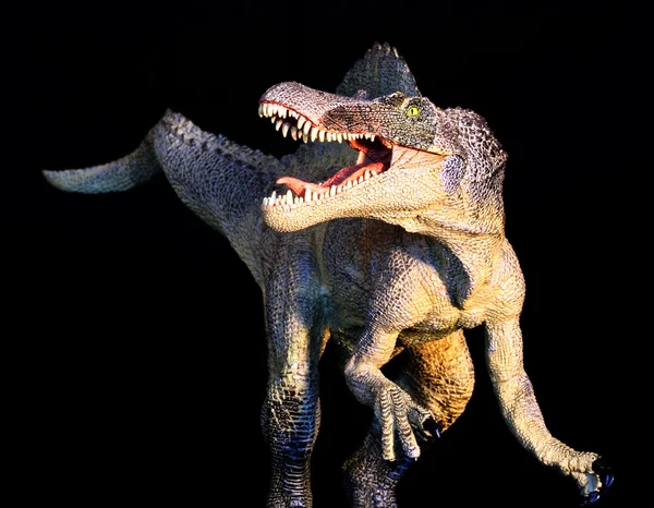 Un dinosauro spinosauro sta su uno sfondo nero — Foto Stock