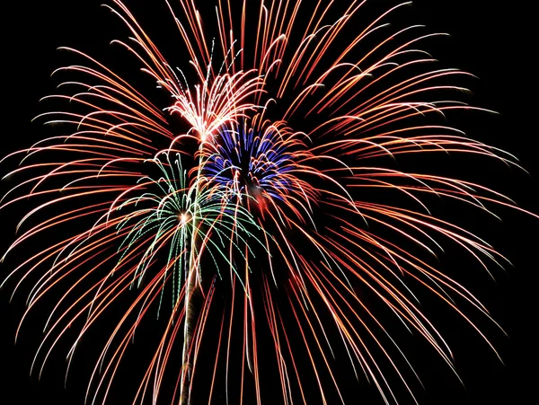 4 juli vuurwerk, rode, blauwe en groene omhoog schiet ontploffen binnen een ora — Stockfoto