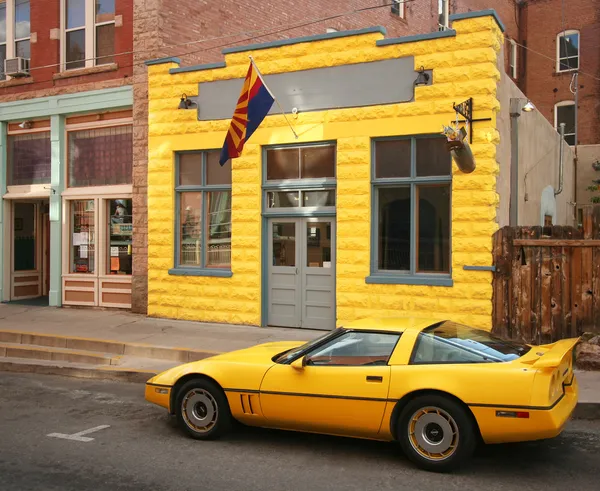 Ein gelber Sportwagen und ein gelbes Gebäude — Stockfoto