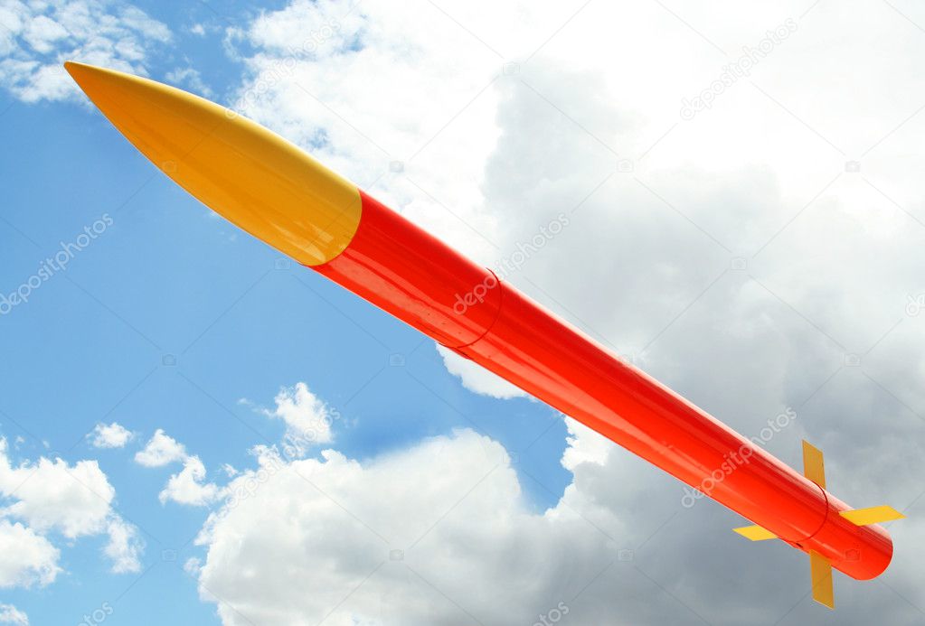 A Yellow and Orange Rocket Against a Cloudy Sky