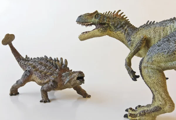 Анкилозавр и аллозавр сражаются на белом фоне — стоковое фото