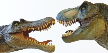 un spinosaurus se enfrenta con un tiranosaurio rex