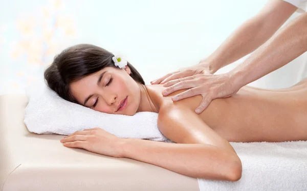 Hermosa mujer morena recibiendo un masaje de espalda — Foto de Stock