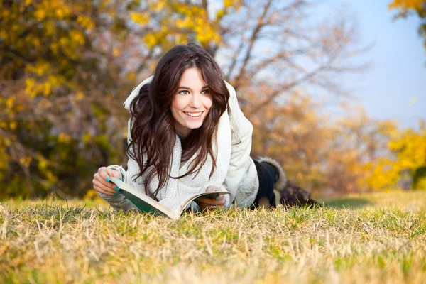 Stock image Beautiful girl with book lying on grass