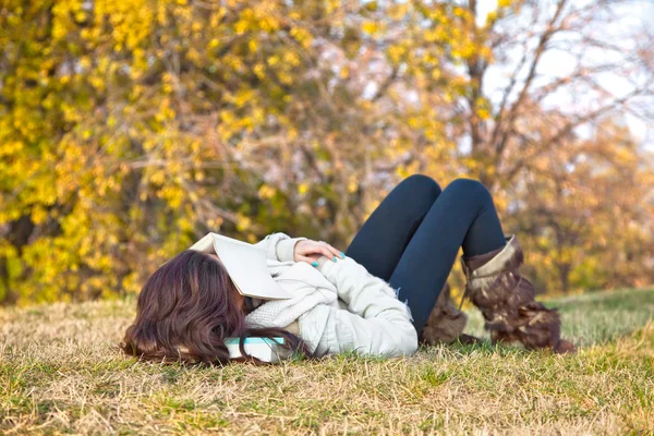 Menina bonita com livro dormindo na grama — Fotografia de Stock