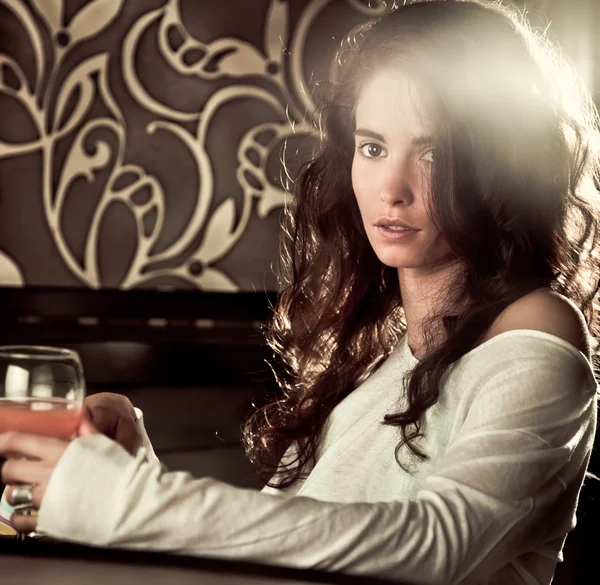 Женщина пьет коктейль в кафе-баре — стоковое фото