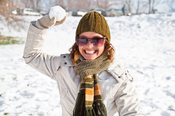 Lykkelig ung kvinne som leker snøballkrig – stockfoto