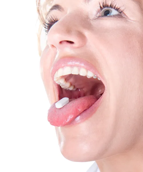Kobieta z pigułki w jej ustach — Zdjęcie stockowe