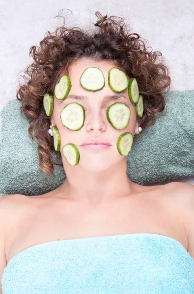 Woman relaxing under a cucumber face masque — Stock Photo, Image