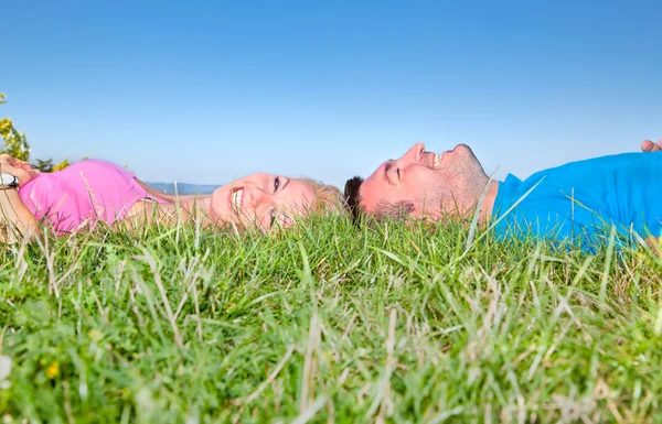 Jovem casal relaxante na grama no parque — Fotografia de Stock