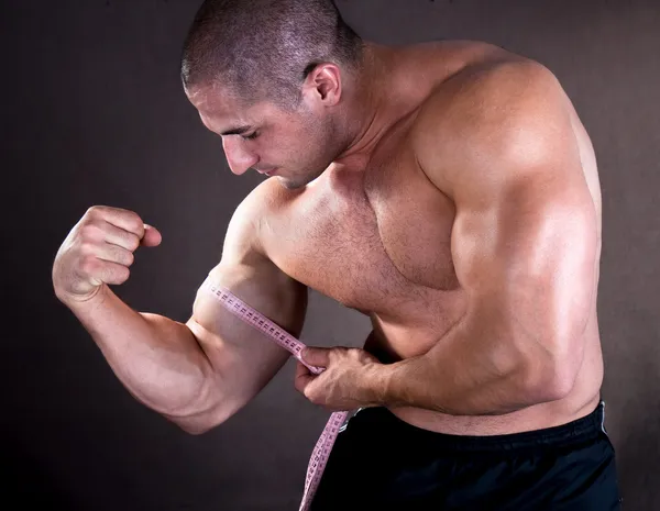 A fiatalember a tökéletes bicepsz mérése — Stock Fotó