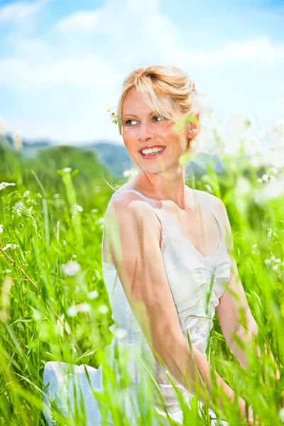 Junge schöne Frau auf dem Gänseblümchenblumenfeld — Stockfoto