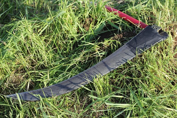 Scythe na trawie — Zdjęcie stockowe