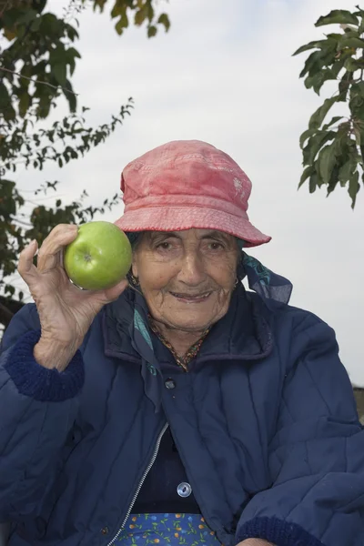 Seniorin mit einem Apfel — Stockfoto