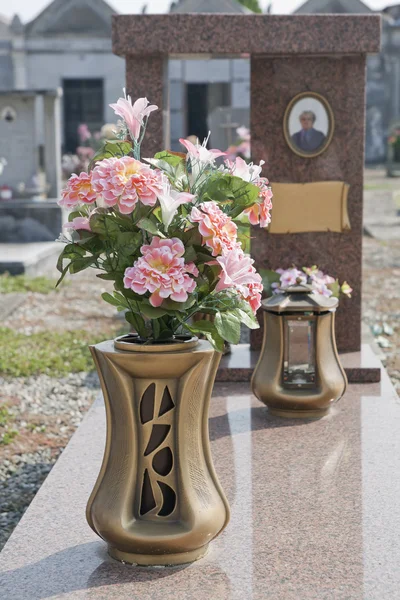 Silk flower vase on graveyard — Stock Photo, Image